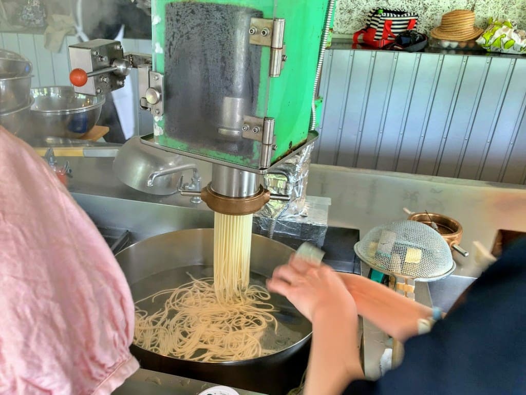 製麺機で麺を押し出し中