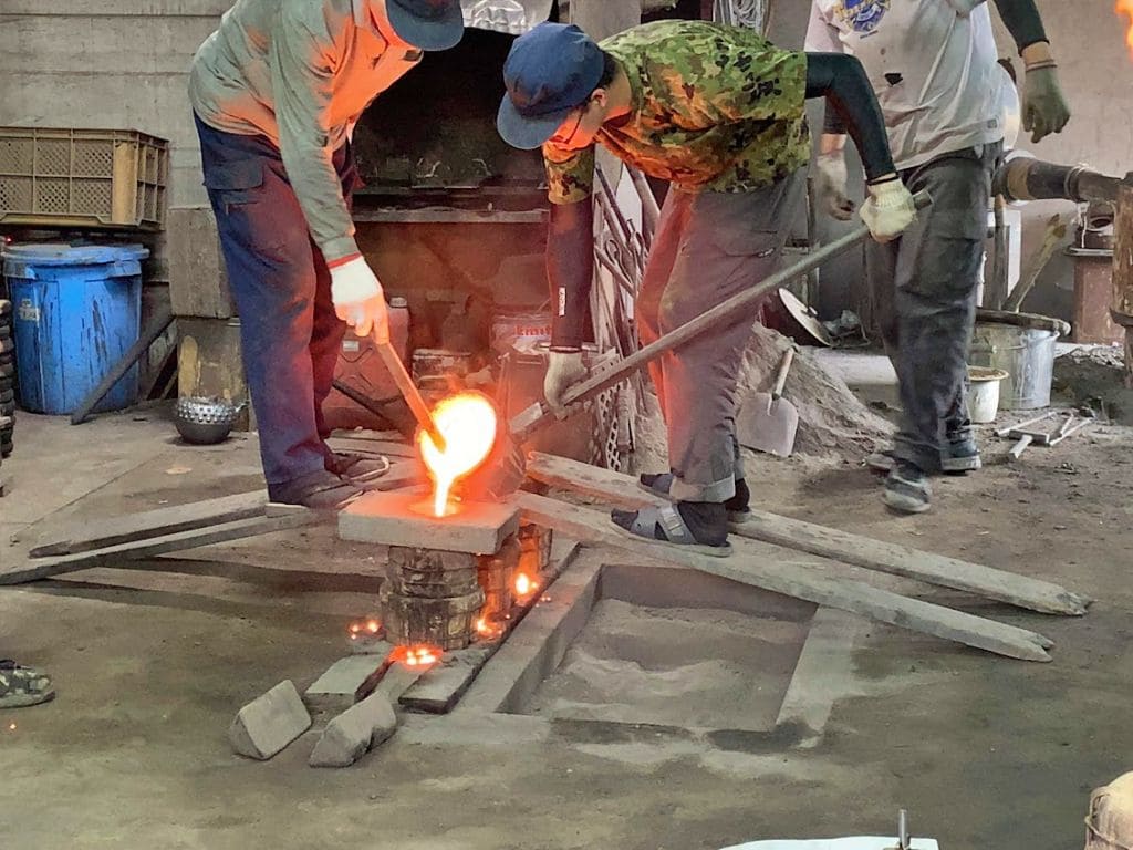 高熱の鉄を型に流し込んでいます